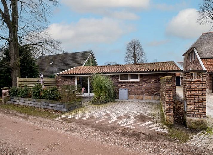 Gezellige woonkamer in Vakantiehuis in Usselo, Twente, met uitzicht op het terras en groene omgeving.