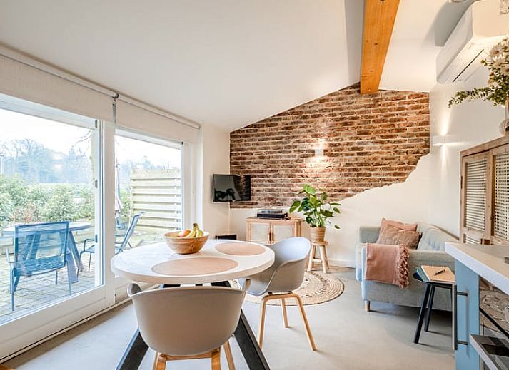 Gezellige woonkamer in Vakantiehuis in Usselo, Twente, met uitzicht op het terras en groene omgeving.