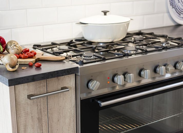 Moderne keuken in Zeldam vakantiehuis, Enter, Twente met houten elementen en ruime eettafel.