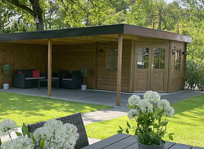 DG630 Ferienhaus in Denekamp, Twente mit sonniger Terrasse und Sonnenschirm auf gruenem Rasen.