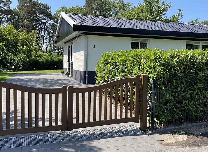 Geraeumige Terrasse mit Sonnenschirm im Ferienhaus DG630 in Denekamp, Twente, umgeben von viel Gruen.