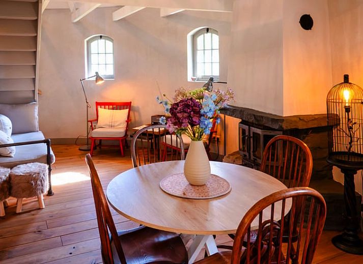 Cozy indoor area of Holiday cottage in Denekamp, Twente, with flowers on the table, ideal place for relaxing moments.