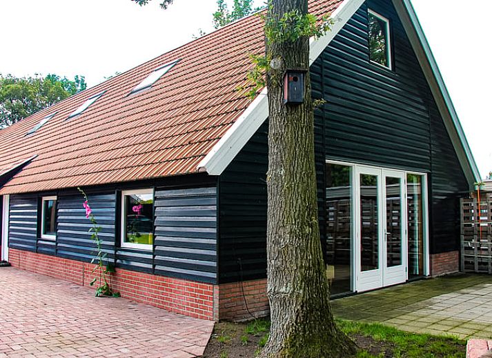 Charming cottage in Denekamp, Twente, with wooden facade and red roof tiles. Perfect vacation home in Overijssel.
