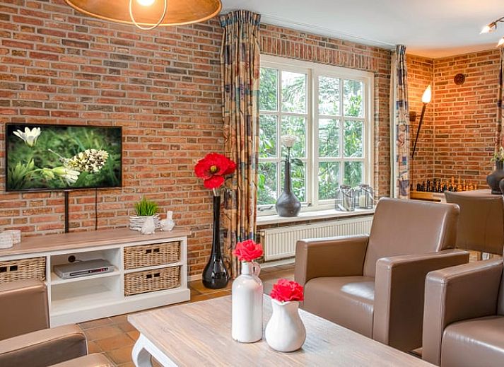Cozy living room in Holiday Home in Losser, Twente, Overijssel with comfortable sofas and garden view.