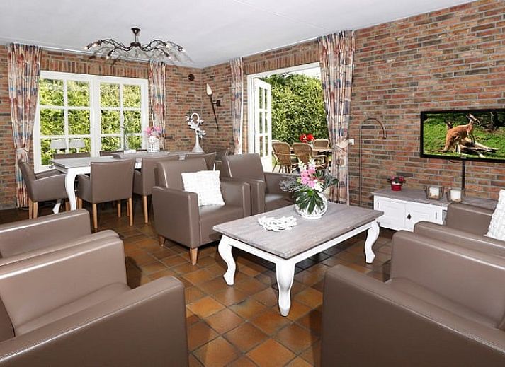 Cozy living room in Holiday Home in Losser, Twente, Overijssel with comfortable sofas and garden view.