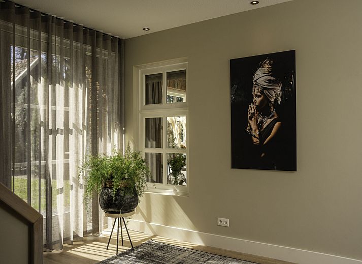 Gezellige woonkamer in Vakantiehuis Het Landhuis, Losser, Twente, met comfortabele zithoek en open haard.