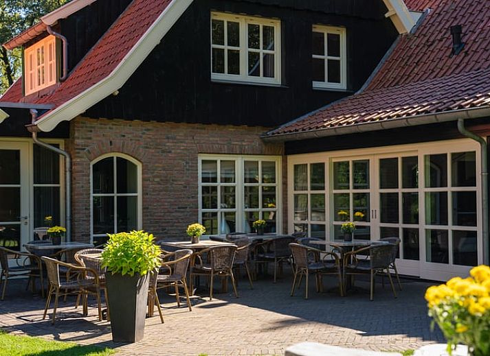 Gezellige woonkamer in Huisje in Losser, Twente, Overijssel, met ruime eettafel en comfortabele zithoek voor een ontspannen verblijf.