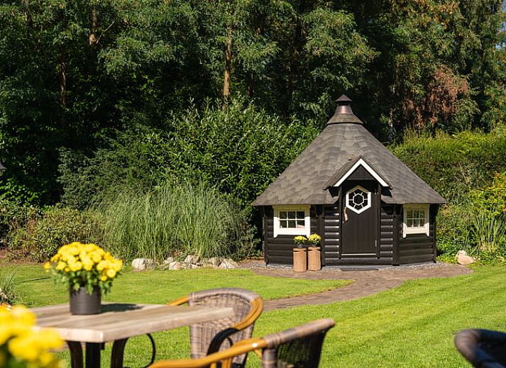 Gezellige woonkamer in Huisje in Losser, Twente, Overijssel, met ruime eettafel en comfortabele zithoek voor een ontspannen verblijf.