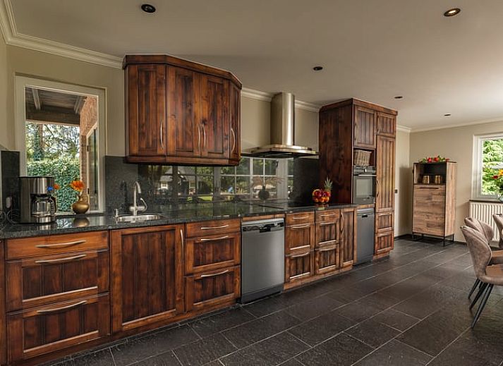 Gezellige eetruimte in Huisje in Losser, vakantiehuis in Twente, Overijssel met uitzicht op de groene tuin en terras.