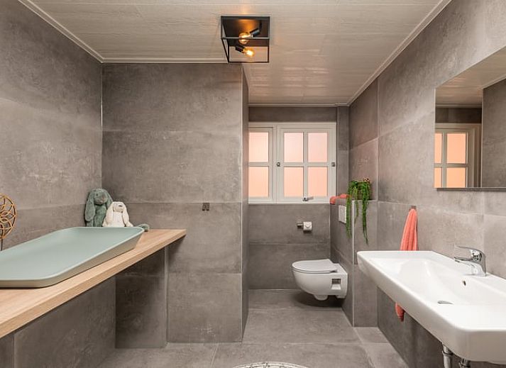 Gezellige eetruimte in Huisje in Losser, vakantiehuis in Twente, Overijssel met uitzicht op de groene tuin en terras.