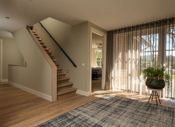 Gezellige eetruimte in Huisje in Losser, vakantiehuis in Twente, Overijssel met uitzicht op de groene tuin en terras.