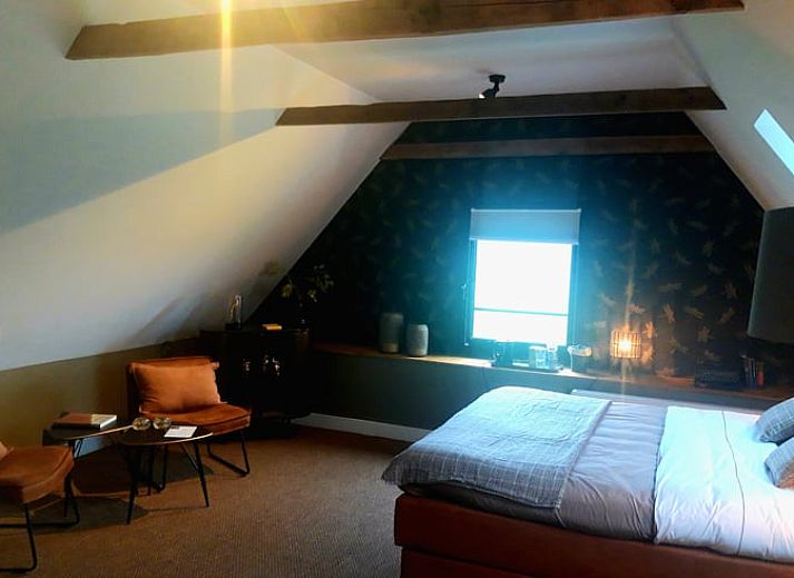 Gemuetliches Schlafzimmer im Huisje in Losser, einem Ferienhaus in Twente, Overijssel, mit einem bequemen Bett und stimmungsvoller Beleuchtung.