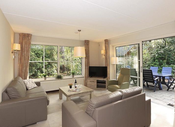 Cozy living room in Boshuus Comfort Plus vacation home in Deurningen, Twente, overlooking green nature.