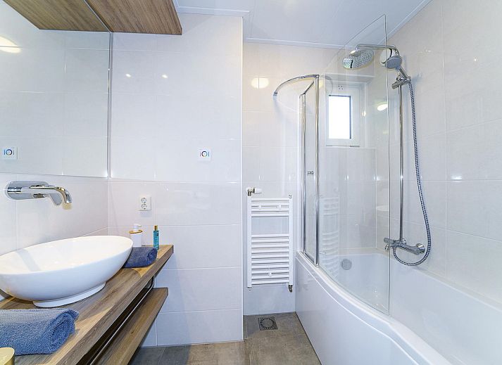 Cozy living room in Boshuus Comfort Plus vacation home in Deurningen, Twente, overlooking green nature.