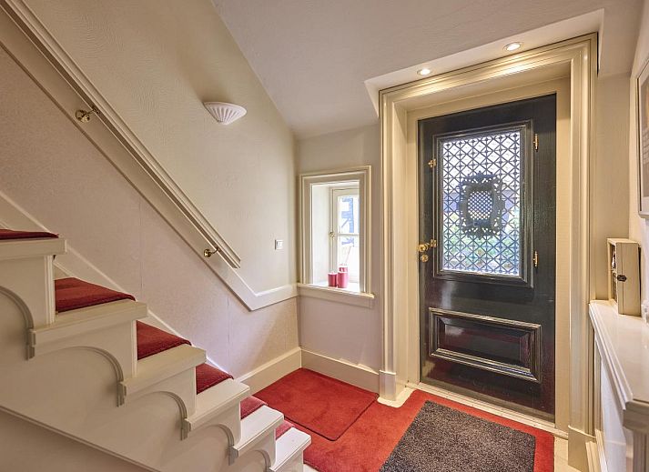 Cozy living room of vacation home Erve Het Klaashuis in Deurningen, Twente, with cozy fireplace and warm furnishings.