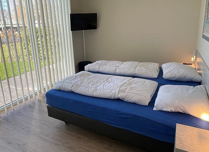 Gezellige woonkamer van Waterlodge 8 in Hoge Hexel, Twente met uitzicht op het meer, comfortabele zitruimte en moderne inrichting.