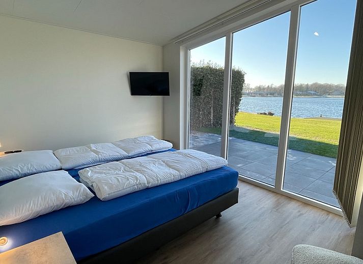Gezellige woonkamer van Waterlodge 8 in Hoge Hexel, Twente met uitzicht op het meer, comfortabele zitruimte en moderne inrichting.