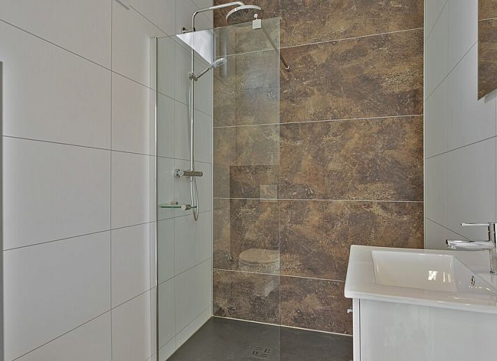 Helles Wohnzimmer im Ferienhaus Regge 4, Hoge Hexel, Twente mit Blick auf die Terrasse und die gruene Umgebung.