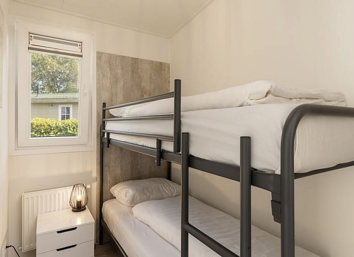 Gemuetliches Wohnzimmer der Waterlodge 6 in Hoge Hexel, Twente, mit Blick auf den See und die gruene Umgebung, perfekt fuer einen entspannten Urlaub.