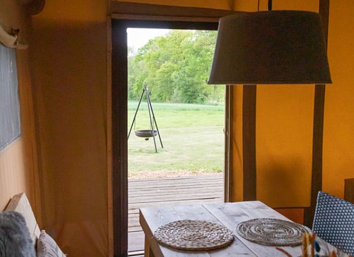 Schaukelstuhl auf der Terrasse des Ferienhauses in Buurse, Twente, Overijssel mit gruener Umgebung.