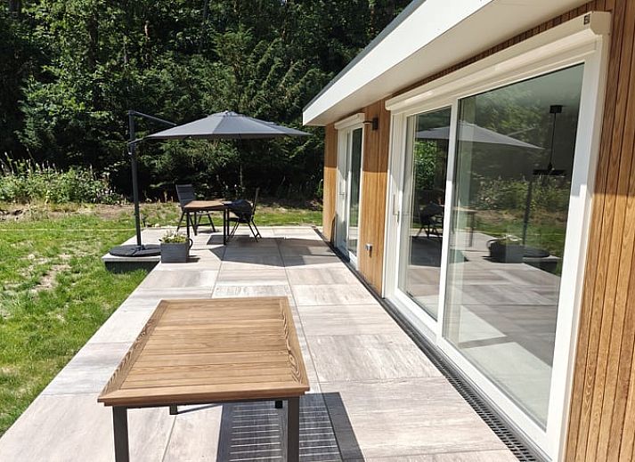 Cozy living room in Cottage in Buurse, vacation home in Twente, with comfortable seating and large windows.