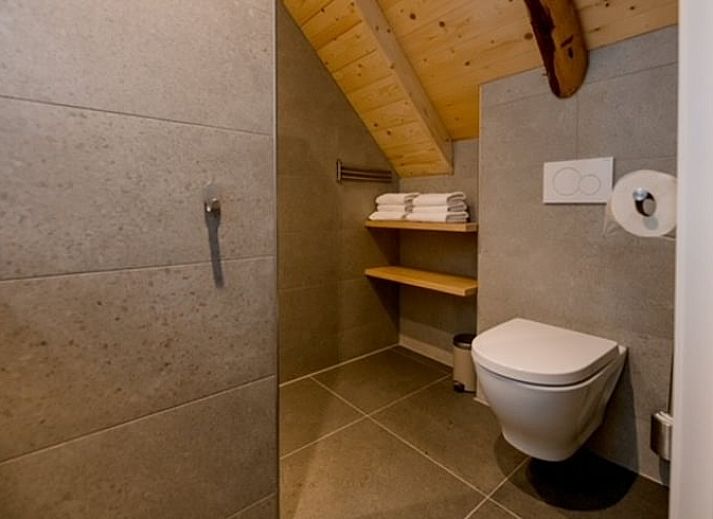 Interior of Huisje in Agelo, vacation home in Twente, Overijssel with wooden beams and artwork on the wall.