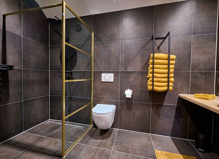 Stylish bar in Holiday Home in Glane, Twente with wooden stools and mood lighting.