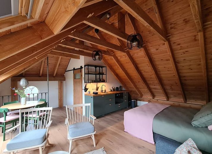 Gezellige binnenruimte van Vakantiehuisje in Hengevelde, Twente met houten balken en zithoek.