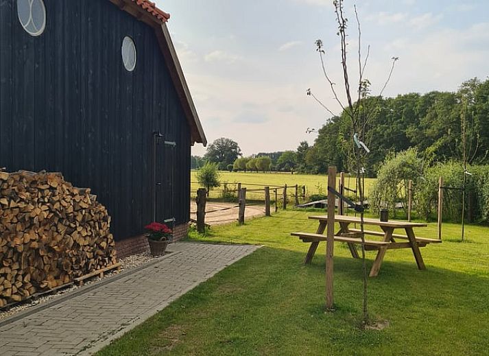 Gezellige binnenruimte van Vakantiehuisje in Hengevelde, Twente met houten balken en zithoek.