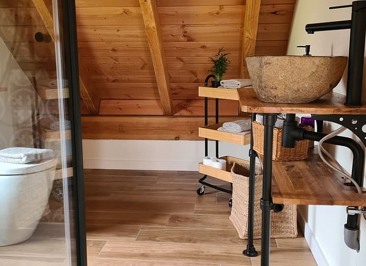 Gezellige binnenruimte van Vakantiehuisje in Hengevelde, Twente met houten balken en zithoek.