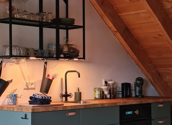 Gezellige binnenruimte van Vakantiehuisje in Hengevelde, Twente met houten balken en zithoek.