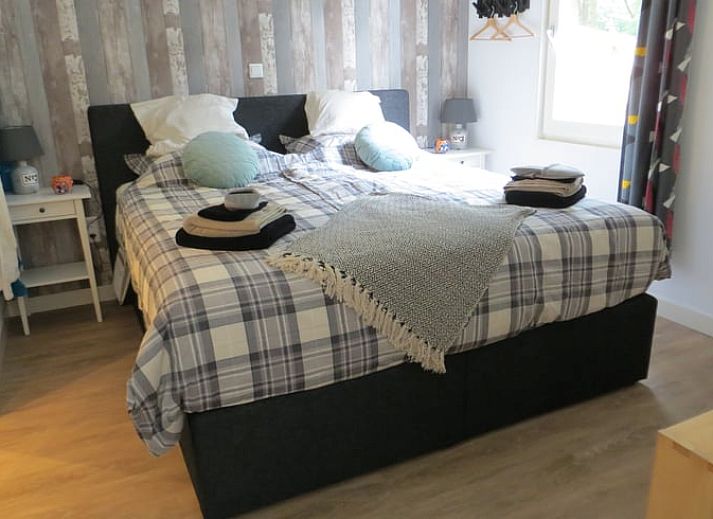 Stilvoller Innenraum im Ferienhaus in Boekelo, Enschede, mit bequemen Stuehlen und einer rustikalen Truhe.