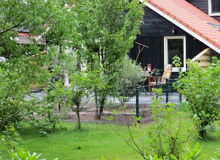 Stilvoller Innenraum im Ferienhaus in Boekelo, Enschede, mit bequemen Stuehlen und einer rustikalen Truhe.