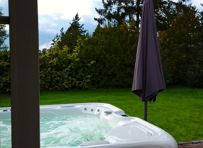 Gemuetliches Wohnzimmer im Ferienhaus in Lonneker, Twente, mit bequemer Sitzecke und stimmungsvoller Beleuchtung.