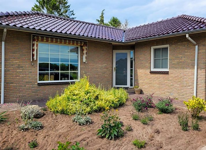 Gemuetliches Wohnzimmer im Ferienhaus in Lonneker, Twente, mit bequemer Sitzecke und stimmungsvoller Beleuchtung.