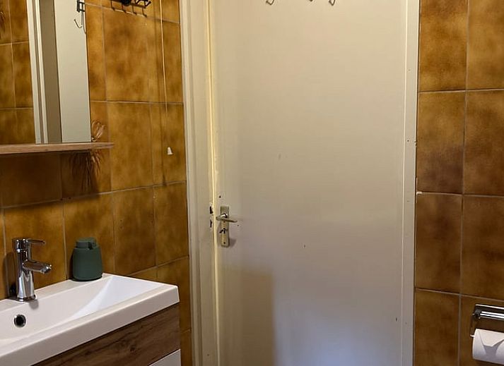 Gemuetliches Wohnzimmer im Ferienhaus in Goor, Twente, Overijssel, mit Weihnachtsbaum und gemuetlicher Sitzecke.