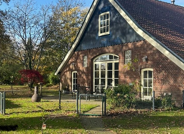 Gemuetliches Wohnzimmer im Ferienhaus in Goor, Twente, Overijssel mit bequemen Sofas und festlichem Weihnachtsbaum fuer eine gemuetliche Atmosphaere.