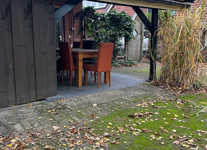 Gemuetliches Wohnzimmer im Ferienhaus in Goor, Twente, Overijssel mit bequemen Sofas und festlichem Weihnachtsbaum fuer eine gemuetliche Atmosphaere.