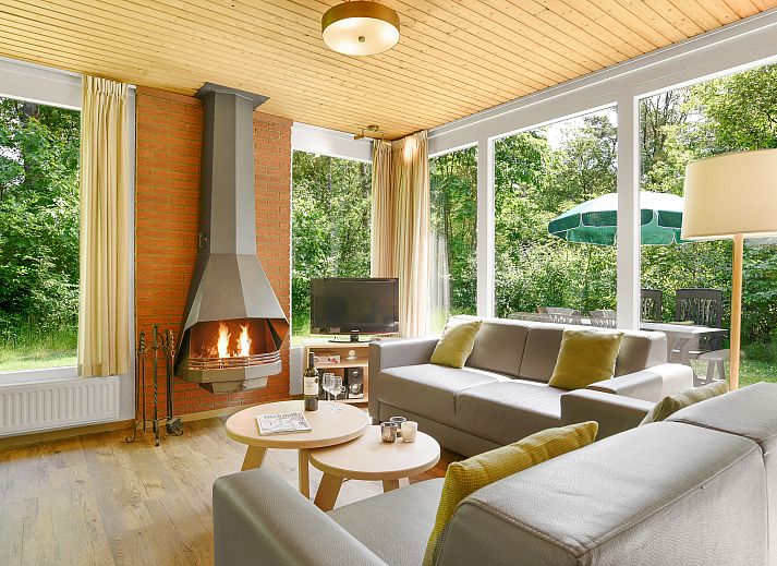 Gezellige woonkamer met open haard in Twenhaarsveld bungalow in Salland, Overijssel.