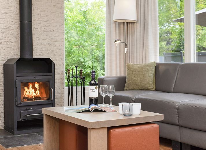 Gemuetliche Sitzecke mit Kamin im Wiedervereinigungsbungalow Twenhaarsveld in Overijssel.