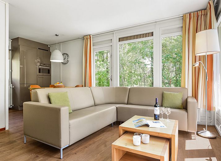 Helles Wohnzimmer in Twenhaarsveld Bungalow Holten mit grossen Fenstern und Zugang zur Terrasse.