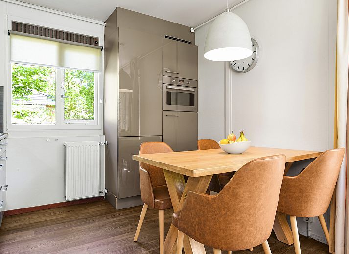 Helles Wohnzimmer in Twenhaarsveld Bungalow Holten mit grossen Fenstern und Zugang zur Terrasse.