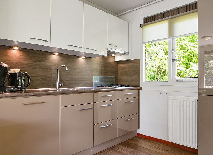 Helles Wohnzimmer in Twenhaarsveld Bungalow Holten mit grossen Fenstern und Zugang zur Terrasse.