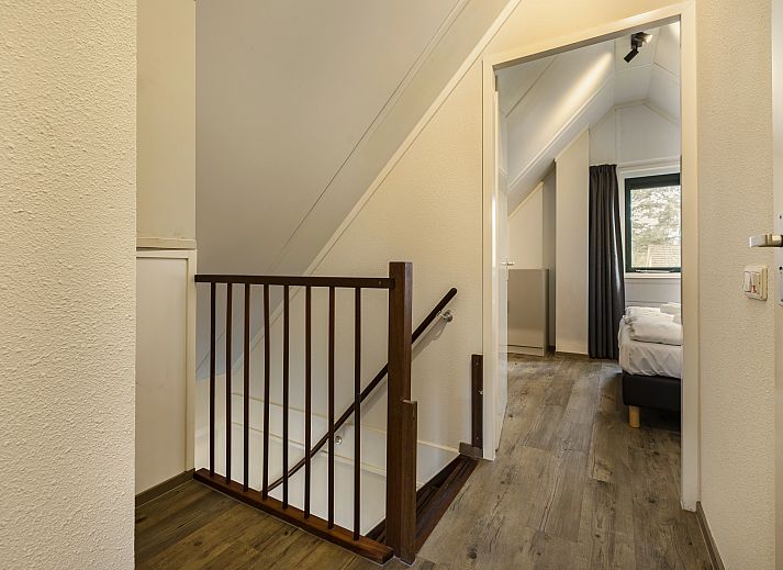 Gemuetliches Wohnzimmer des 6-Personen-Hundebungalows Twenhaarsveld in Holten, Overijssel mit bequemer Sitzecke und gemuetlichem Holzofen.