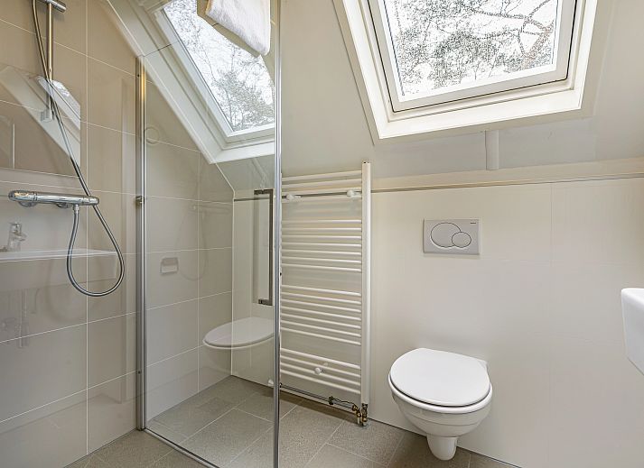 Gemuetliches Wohnzimmer des 6-Personen-Hundebungalows Twenhaarsveld in Holten, Overijssel mit bequemer Sitzecke und gemuetlichem Holzofen.