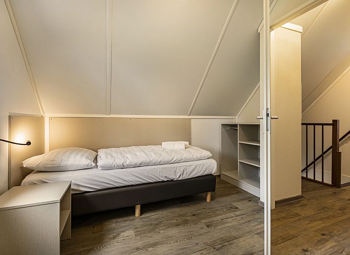 Gemuetliches Wohnzimmer des 6-Personen-Hundebungalows Twenhaarsveld in Holten, Overijssel mit bequemer Sitzecke und gemuetlichem Holzofen.