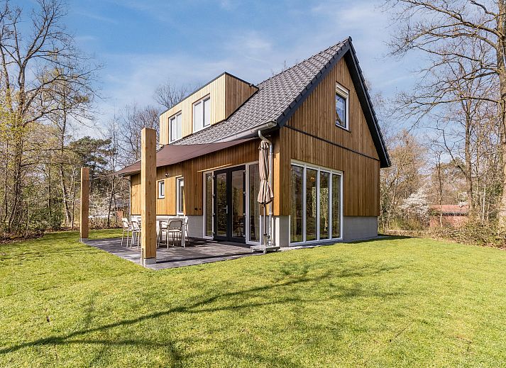 Gemuetliches Wohnzimmer mit grossen Fenstern im Bungalow Twenhaarsveld, Holten, Overijssel, ideal zum Entspannen.