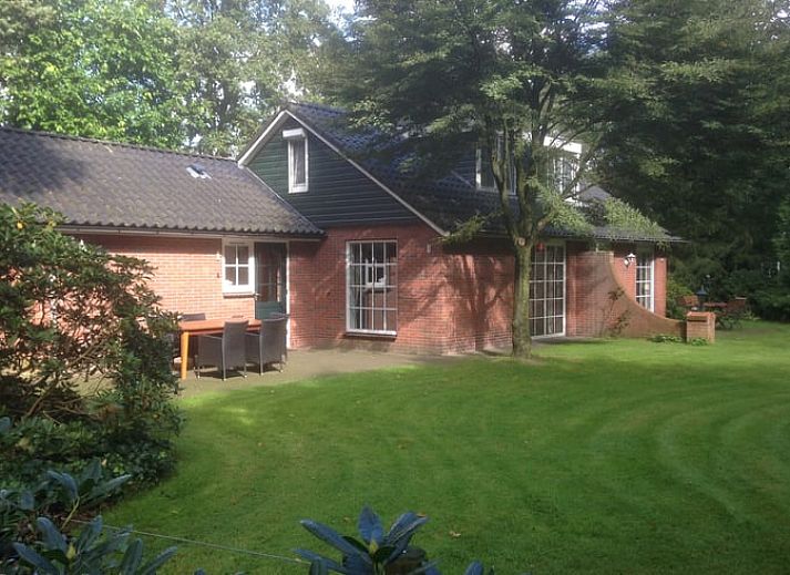 Gemuetliches Wohnzimmer im Ferienhaus in Holten, Overijssel mit komfortabler Sitzecke und grossen Fenstern mit Blick auf die Natur.