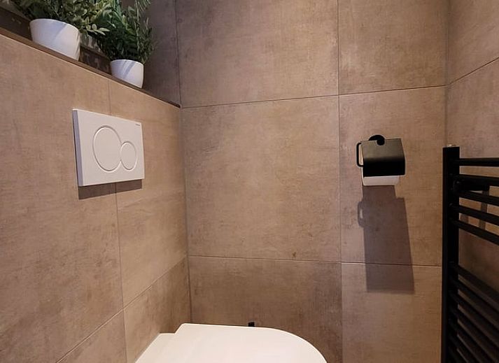 Gezellige woonkamer in Vakantiehuis in Holten, Salland, Overijssel met moderne inrichting en uitzicht op groene omgeving.