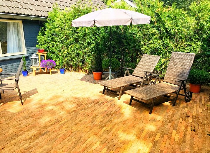 Gezellige woonkamer bij boerderijhuisje.nl in Luttenberg, vakantiehuis in Salland, Overijssel met uitzicht op groene tuin.